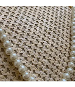 Detailed macro shot of round white pearls with natural luster on a woven straw background