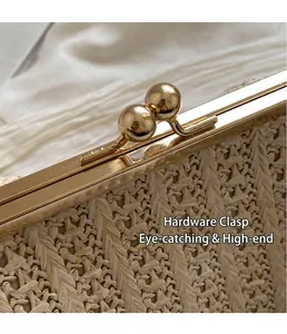 Detail of woven straw bag with golden metal kiss lock and textured V-shaped pattern