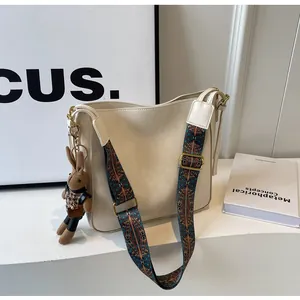 Detail van de crème emmertas met geometrische riem en schattig pluche konijntje
