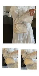 Detail of pearl strap and gold metal clasp on ivory woven shell evening bag