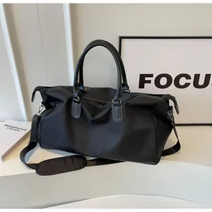 Detail of black large capacity travel bag with reinforced handles and sturdy metal hardware