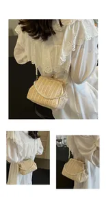 Detail of woven straw shell bag featuring elegant pearl strap and gold metal clasp