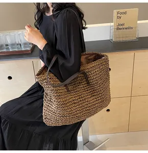 Detalle de bolso tote de paja tejida con correas de cuero marrón sobre una modelo en escena cálida