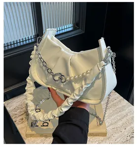 Close-up of white ruched cloud bag with silver chain, pearls and leather straps