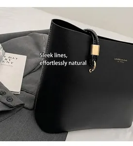 Detail view of black PU tote bag with white stitching and gold buckle hardware
