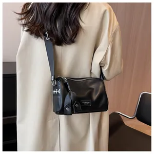 Detail of black leather Boston bag with a black and white lettered wide shoulder strap
