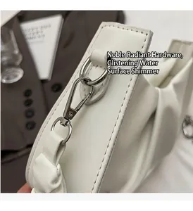 Close-up of polished silver hardware and white pleated leather texture on a cloud bag