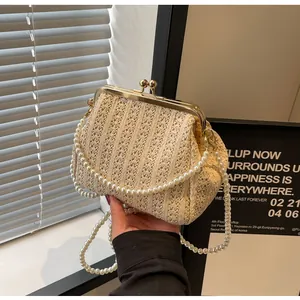 Close-up of retro ivory woven shell bag featuring an elegant pearl handle and gold clasp