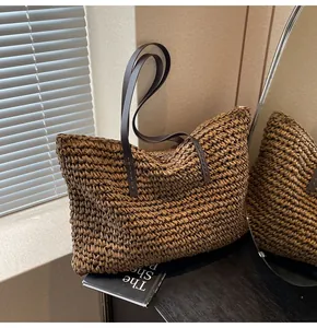 Detalle macro de la textura de paja tejida y asas de cuero marrón en el bolso tipo tote