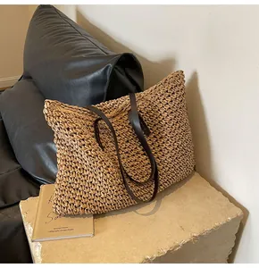 Detalle de la textura del bolso tote de paja tejida con asas finas de cuero marrón café