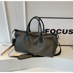 Olive green travel duffel with black shoulder strap and double zipper detail