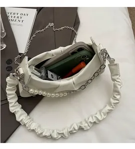 Interior view of white ruched bag showing capacity for two phones, perfume and lip gloss