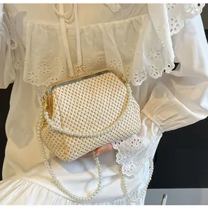 Macro detail of beige woven shell handbag with gold clasp and elegant pearl handle strap
