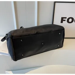 Detailed view of black travel bag with synthetic leather base and five metal protective feet