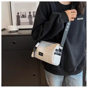 Close-up of white pebble grain leather crossbody bag with stylish fashion lettering