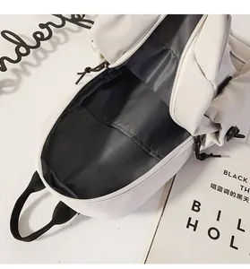 Detalle de bandolera de lona blanca con bolsillo interior y cierre de cremallera en negro