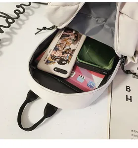 Primer plano del espacioso interior de bolso blanco con móvil, batería y tableta
