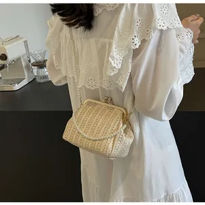 Detail of hand-woven beige raffia bag with elegant pearl chain and vintage metal clasp