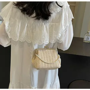 Detail of straw woven shell bag featuring pearl straps and vintage metal clasp closure
