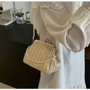 Detailed macro view of beige woven shell bag featuring vintage gold clasp and pearl chain