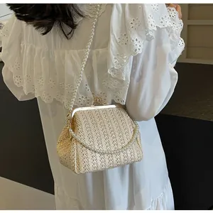 Detail of straw woven shell handbag with pearl strap and vintage metal clasp