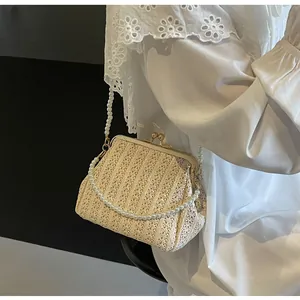 Detailed view of woven shell bag with golden metal clasp and faux pearl shoulder strap