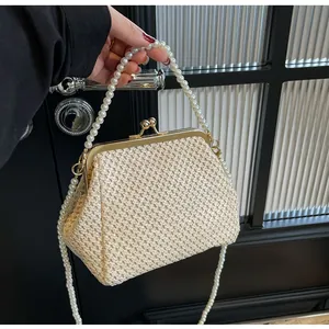 Close-up of beige woven texture bag featuring vintage metal clasp and pearl chain handles