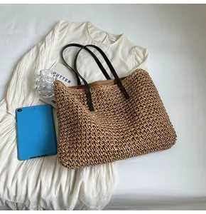 Detalle de la textura tejida del bolso tote con asas negras delgadas para hombro