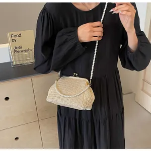 Detail of beige woven shell bag with vintage gold clasp and elegant pearl shoulder strap