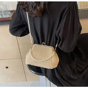 Detail view of woven straw shell bag with pearl strap and vintage golden metal clasp