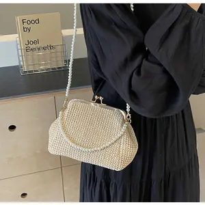 Close-up of retro woven shell bag with pearl chain straps and gold kiss-lock frame