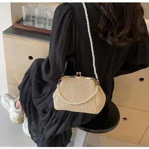 Detail of vintage beige woven shell bag with double pearl chains in a cozy interior setting