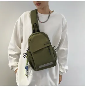 Detalle de la bolsa de pecho de nailon verde militar con letras y tira reflectante