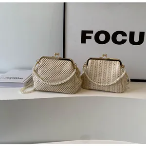 Detail of straw woven shell bags featuring golden metal clasps and elegant pearl straps