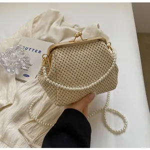 Detail of vintage straw woven shell bag with gold clasp and elegant pearl handle