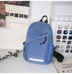 Detalle del bolso bandolera de nailon azul con logotipo y tira reflectante de seguridad