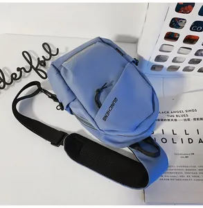 Detalle de la bolsa de pecho azul claro impermeable con bolsillos de cremallera y correa ajustable