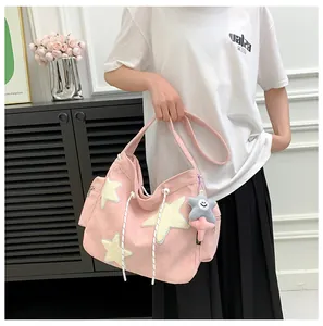 Détail du cabas en velours côtelé rose avec écussons étoiles et pendentif étoile peluche