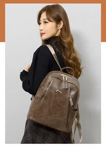 Detail of dark brown faux leather backpack featuring gold hardware and woven straps