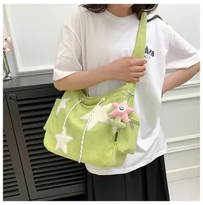 Détail du sac en velours côtelé vert avec étoiles et porte-clé en peluche mignon