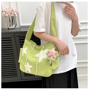 Détail du sac cabas en velours côtelé vert clair avec étoiles blanches et charm étoile rose