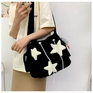 Détail d'un sac à bandoulière en velours noir avec étoiles en peluche et cordon décoratif