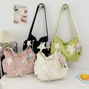 Détail de sacs bandoulière en velours côtelé avec patchs étoile et charms en peluche