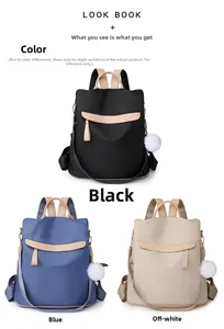 Trois sacs à dos antivol légers en noir, bleu et beige avec des pompons en peluche