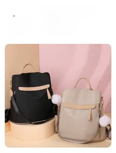 Sacs à dos minimalistes en nylon noir et beige avec pompon en fausse fourrure