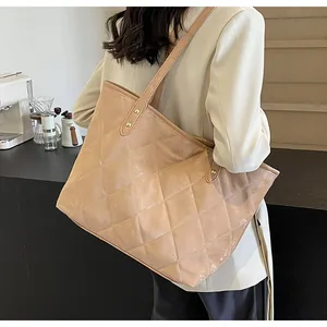 Close-up of quilted diamond pattern tote bag with reinforced leather shoulder straps
