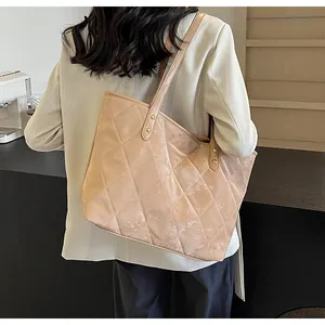 Close-up of quilted velvet tote bag with golden stud details on a slim shoulder strap