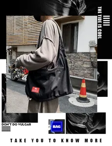 Detail of the black canvas hobo bag showing the brand label and spacious zipper pocket