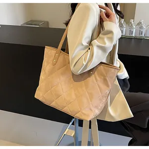 Detail shot of khaki quilted tote bag with matte texture and reinforced rivets