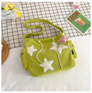 Détail du sac en velours côtelé vert clair avec étoiles en peluche et poche zippée